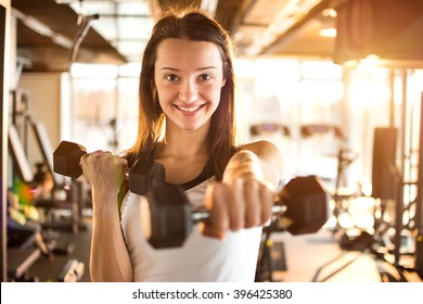 Young Woman Hang Up Hand Weights