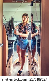 Young Woman Hanging Clothes On A Clothesline Inside Her Camper Van During A Trip