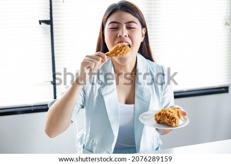 Young woman was happy to eat the delicious fried chicken. fried chicken drumstick