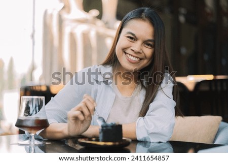 Young woman is happy and enjoys eating sweets and coffee at a cafe. 