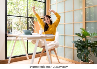 Young Woman Happy Listen Music For Chill And Relax After Finish Work.   Lifestyle Girl Using Laptop For Meeting And Working  In Living Room At Home.  Lifestyle Concept 