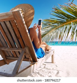 Young Woman In Hat With Mobile Phone At The Beach