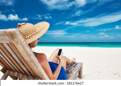 Young Woman In Hat With Mobile Phone At The Beach