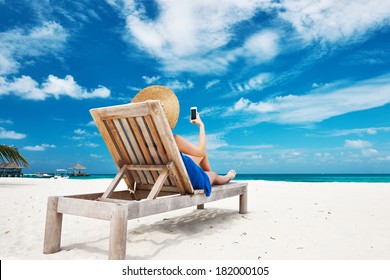 Young Woman In Hat With Mobile Phone At The Beach