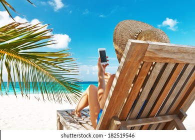 Young Woman In Hat With Mobile Phone At The Beach