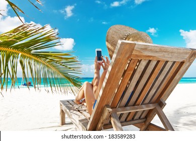 Young Woman In Hat With Mobile Phone At The Beach