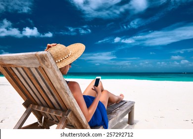 Young Woman In Hat With Mobile Phone At The Beach