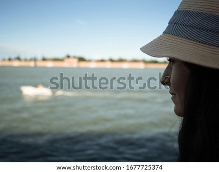 Young woman with a hat on looking at city view, Venice, Italy