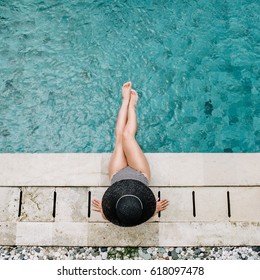 Young Woman In Hat Relaxing Near Swimming Pool. Top View