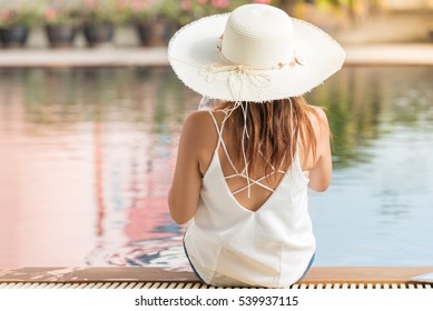 Young Woman With Hat Sit On Pool  