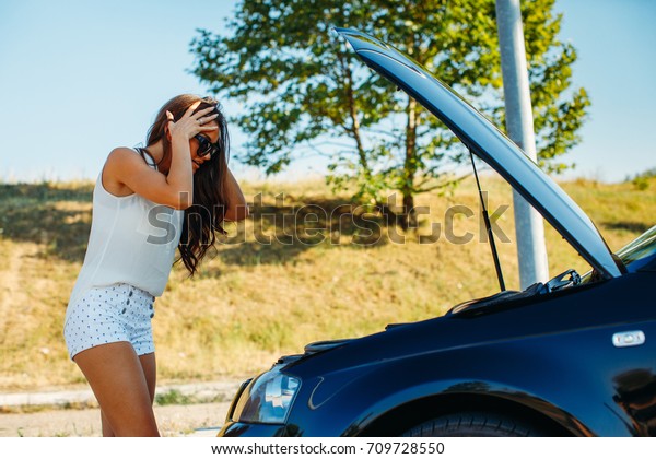 Young woman have car\
problem on the road