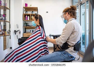 Young Woman Have Hair Cutting At Hair Stylist During Pandemic Isolation, They Both Wear Protective Equipment. Hair Dresser Working With A Face Mask During Coronavirus Quarantine