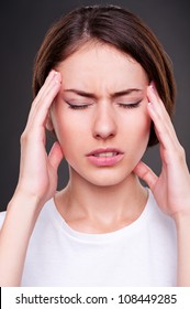 young woman have a headache. studio shot over dark background - Shutterstock ID 108449285
