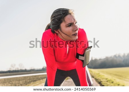Young woman having a break from running in the countryside