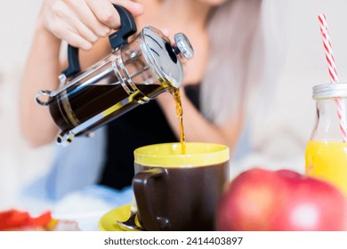 Young woman having breakfast in bed pouring coffee into cup - Powered by Shutterstock