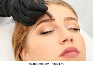 Young Woman Having Eyebrow Correction Procedure In Beauty Salon