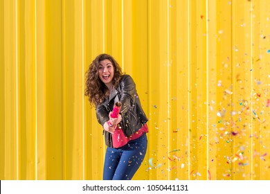 Young Woman Having Fun With Confetti Over Yellow Background. Outdoors. Fun And Lifestyle Concept