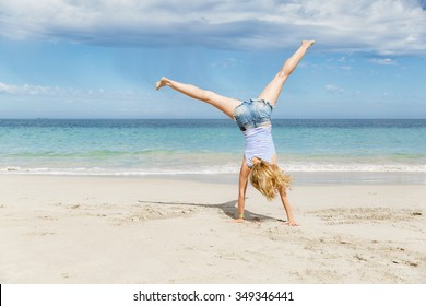 Young woman having fun and jumping on beach - Powered by Shutterstock