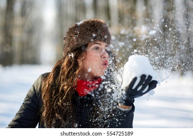 Young woman having fun outdoor in the snow, closeup with selective focus