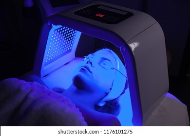 Young Woman Having LED Light Facial Treatment In Beauty Salon