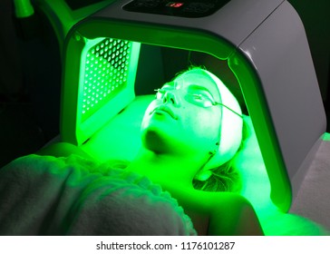 Young Woman Having LED Light Facial Treatment In Beauty Salon