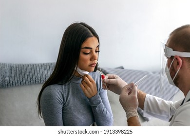 Young woman having a nasal swab test done by her doctor. Shot of Caucasian young woman having a nasal swab test done by her male doctor. Male lab doctor taking a nasal culture sample with cotton swab.