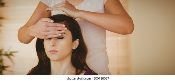 Young Woman Having A Reiki Treatment In Therapy Room