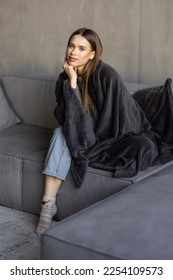 Young woman having a rest. Wrapped up in white blanket and drinking coffee in warm atmosphere, copy space - Shutterstock ID 2254109573