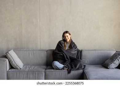 Mujer joven descansando. Envuelto en una manta blanca y tomando café en un ambiente cálido, espacio de copias
