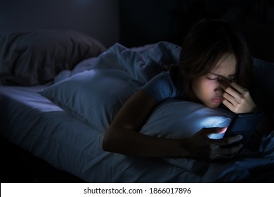 Young Woman Having Sore And Tired Eyes When Using Smartphone While Lying In Bed At Night