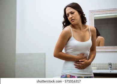 Young Woman Having Stomach Pain In Bathroom At Home