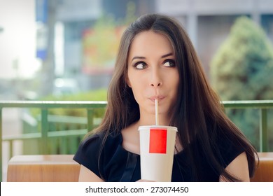 Young Woman Having a Summer Refreshing Drink Outside - Portrait of a funny girl drinking trough a straw
