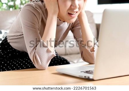 
A young woman having trouble (stress) in front of a laptop