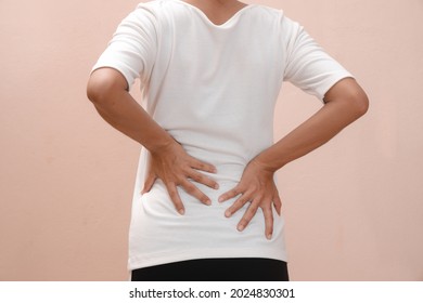 Young woman having waist pain, muscle or chronic nerve pain in her back after working. Health Issue, diseases of the musculoskeletal system concept. 