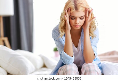 young woman with a headache, was sick in bed in the bedroom - Shutterstock ID 1545453035