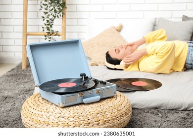 Young woman with headphones and record player in bedroom, closeup - Powered by Shutterstock