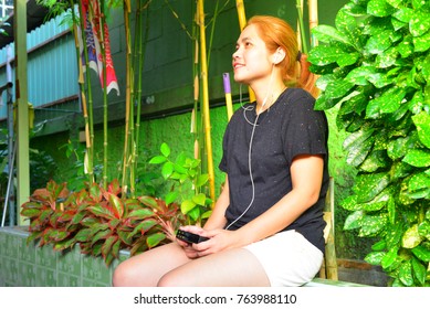 Young Woman With Headphones And A Walkman Listening To Music