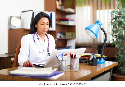 Young Woman Healthcare Worker Working In Medical Office Using Laptop Computer