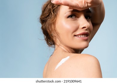 Young Woman With Healthy Glowing Skin And Sunscreen Cream On Shoulder Covering Face With Hand From Sun. Smiling Pleased Female Applying Moisturizing Body Care Lotion. Skincare Cosmetics Advertisement.