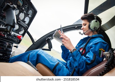 Young Woman Helicopter Pilot Reading Map.