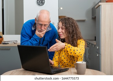 Young Woman Helps Senior On A Laptop Computer