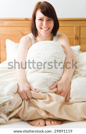 Young woman in her bed smiling