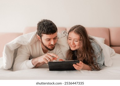 Young woman and her beloved husband on this special day. Couple in love in tablet online shopping. Concept of gifts for birthdays, Christmas, Valentine's Day and Men's Day. Part of a series. - Powered by Shutterstock