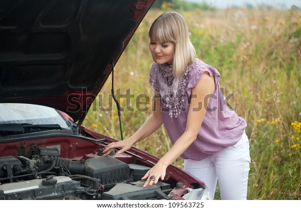 young woman with\
her broken car in summer\
day