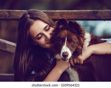 Young woman and her collie dog in park, she is hugging and kissing him. Vintage style color.