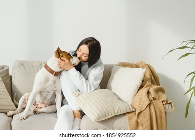 Young woman with her cute dog at home. Lovely pet - Shutterstock ID 1854925552