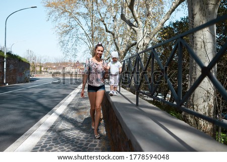 Similar – Happy young people walking along road in summer day