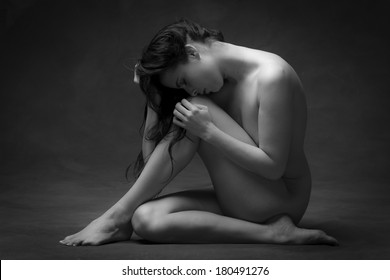 Young woman, in her early twentys shot as an implied nude, from the side. This image shows a certain vulnerability, and captures a deep emotion, of someone letting you see that vulnerability.