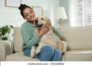 Young woman and her Golden Retriever on sofa at home. Adorable pet - Powered by Shutterstock