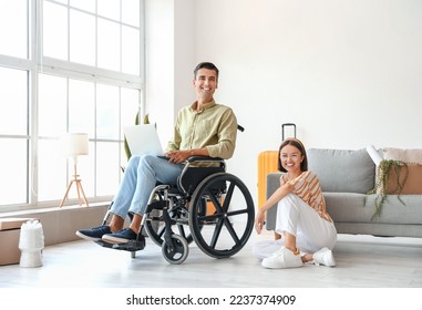 Young woman and her husband in wheelchair in room on moving day - Powered by Shutterstock